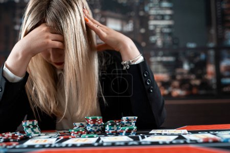 Téléchargez les photos : Bouleversé femme pertes jeu de poker au casino, concept de jeu, chance et fortune - en image libre de droit