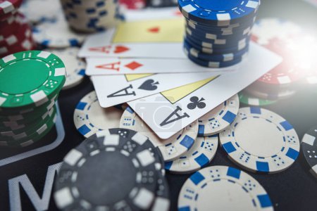 La combinación ganadora es de cuatro cartas de ases y fichas en la mesa del casino. Poker juego 