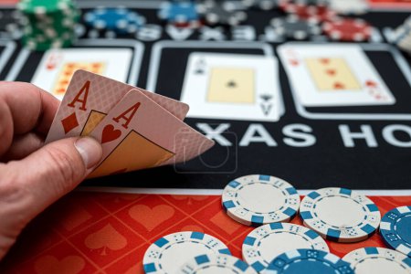 jugador está sosteniendo dos cartas de as - ganar combinación en el póquer. Concepto de juego