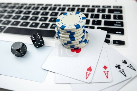 Business-Online-Pokerspiele mit Laptop, zwei schwarzen Würfeln und Casino-Chips. Glücksspielkonzept