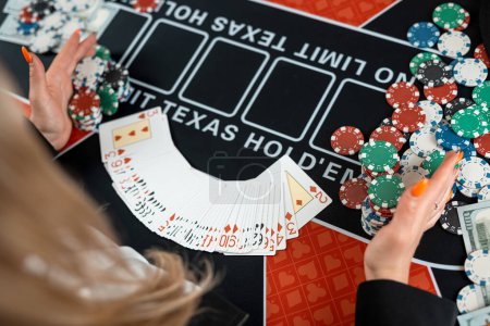 Foto de Manos de croupier femenino están tomando cartas de juego en la mesa de póquer en el casino. Concepto de juego - Imagen libre de derechos