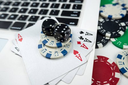Business-Online-Pokerspiele mit Laptop, zwei schwarzen Würfeln und Casino-Chips. Glücksspielkonzept