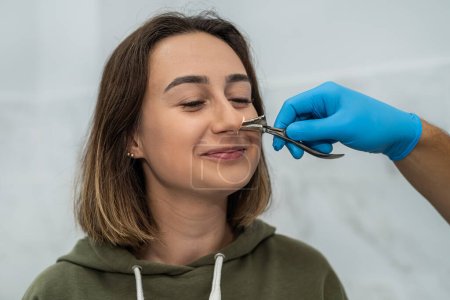 Porträt eines Hals-Nasen-Ohren-Arztes bei der Arbeit mit einer Patientin mit Nasenproblemen. Medizin. Untersuchung der Nasennebenhöhlen