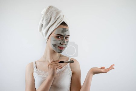 Téléchargez les photos : Portrait de belle femme faisant des traitements de beauté utilisent masque d'argile et tenir le pinceau isolé sur blanc. Concept de beauté et de santé, traitement anti-âge - en image libre de droit