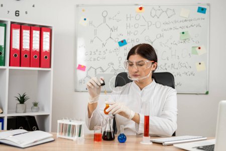 Foto de Mujer científica química mezclando líquido en vidrio de laboratorio con pipeta, medicina e investigación en química. Concepto de investigación farmacéutica - Imagen libre de derechos