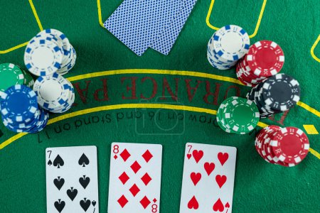 Tarjetas de póquer con tres de un tipo o conjunto de combinación. Primer plano de la mano del jugador toma cartas en el club de póquer