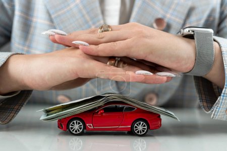 Versicherung oder Schutz des Autos mit Dollargeld und der Hand des Vechicle. Autovermietung oder Verkauf