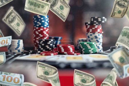 Téléchargez les photos : Jetons de poker pile sur la table au casino, argent de pluie voler dollar comme une grande chance de gagner. Concept de jeu - en image libre de droit