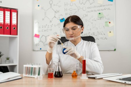 Téléchargez les photos : Femme scientifique chimiste mélangeant liquide en verre de laboratoire avec pipette, médecine et recherche en chimie. Concept de recherche pharmaceutique - en image libre de droit