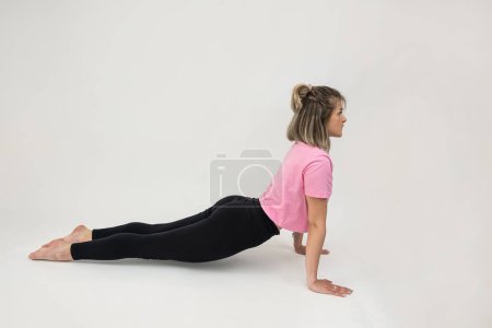 Téléchargez les photos : Mince femme de remise en forme montre des poses de gymnastique et des exercices isolés. Concept sportif - en image libre de droit
