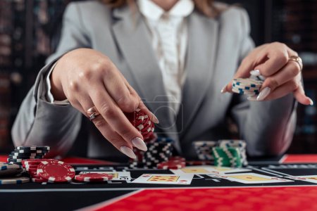 Spielerin spielt Poker und nimmt Chips, um den Einsatz zu erhöhen. Casinospiel