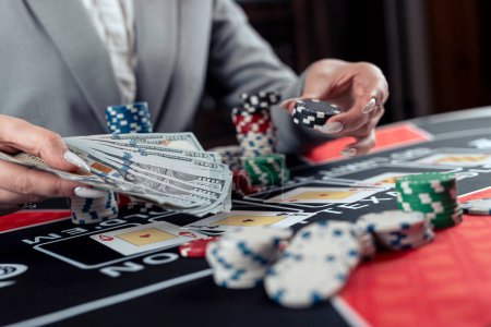 Spielerin spielt Poker und nimmt Chips, um den Einsatz zu erhöhen. Casinospiel