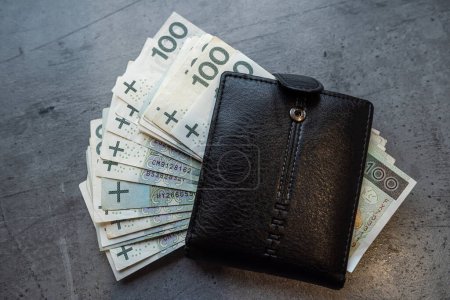 200 100 zloty banknotes in a black male wallet. Home budget and finance saving concept