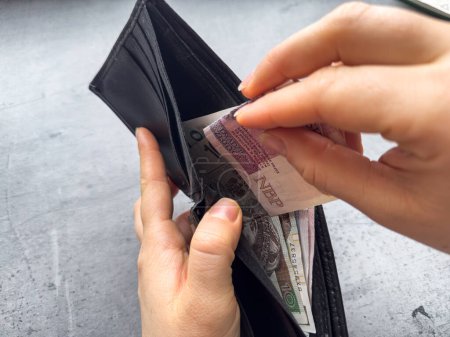 Nahaufnahme Frau zieht polnischen Zloty Geld aus Brieftasche. Polnische Wirtschaft. Frau zählt das Geld