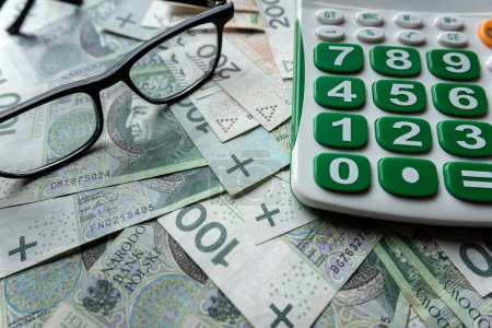 pln polnischen Zloty Geld mit Taschenrechner mit Brille sparen Finanzkonzept. Berechnung und Buchhaltung