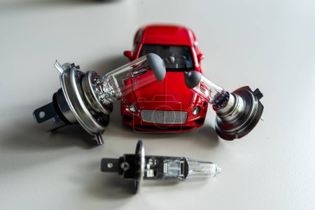 different automotive bulbs h1 h4 h7 a small toy car. Car repair conecpt