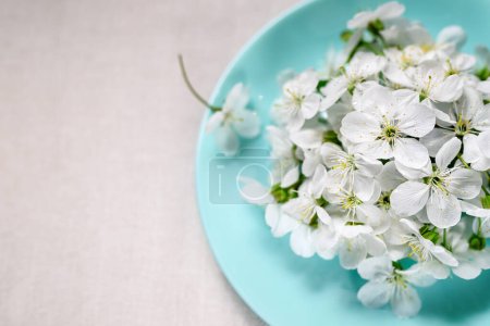 Foto de Spring composition, flowers on a plate. Round turquoise plate with white cherry flowers. Cotton fabric and chopsticks, copy space. Easy food concept, zero calorie, weight loss, fasting, diet. - Imagen libre de derechos