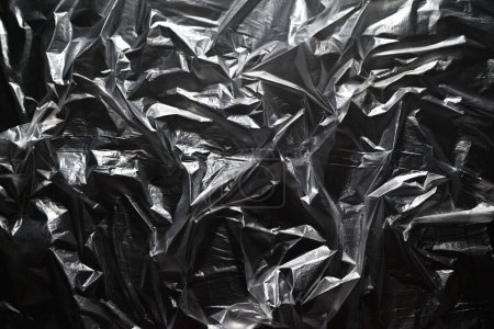 Téléchargez les photos : Texture d'un sac transparent en plastique sur fond noir. - en image libre de droit