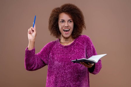Foto de Tomando notas. Mujer joven en blusa violeta con un cuaderno en las manos - Imagen libre de derechos