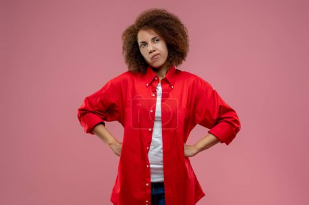 Photo for In thoughts. Pretty curly-haired woman in red jacket looking thoughtful - Royalty Free Image