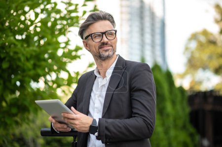 Photo for Businessman. Mature man in eyeglasses with a tablet in hands - Royalty Free Image