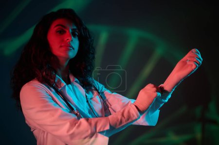 Photo for Sterile gloves. Female doctor in coveralls putting the gloves on - Royalty Free Image