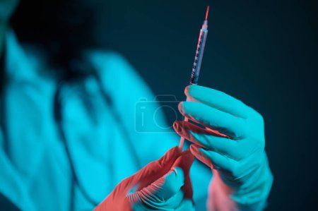 Téléchargez les photos : Vaccination. Médecin brun avec une seringue à la main - en image libre de droit