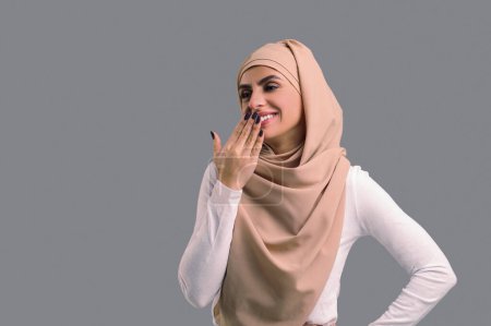 Foto de Mujer feliz. Mujer joven árabe en hijab beige mirando feliz y contento - Imagen libre de derechos