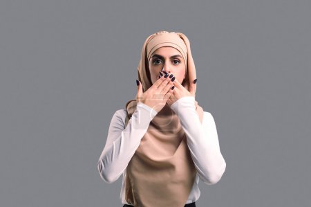 Foto de Mujer sorprendida. Mujer árabe joven en hijab mirando sorprendido y sorprendido - Imagen libre de derechos