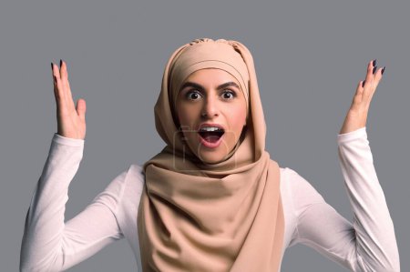 Foto de Mujer sorprendida. Mujer árabe joven en hijab mirando sorprendido y sorprendido - Imagen libre de derechos