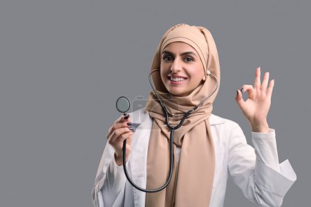 Téléchargez les photos : Médecin féminin. Jeune femme médecin dans le hijab regardant confiant - en image libre de droit