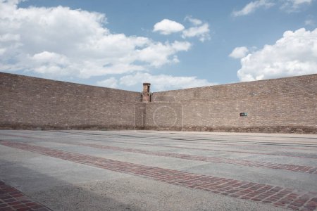 Téléchargez les photos : Une grande cour de prison coûterait cher. Avec murs et tour de pierre avec ciel bleu et nuages, faisant partie du Musée Leonora Carrington, sans personnes - en image libre de droit