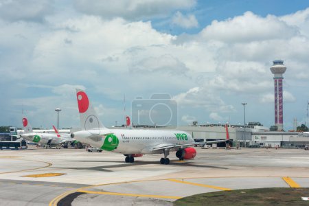 Foto de Cancun, quintana roo, 20 08 23, Dos aviones de la aerolínea mexicana estacionados en el aeropuerto durante un día nublado y personas que llevan equipaje - Imagen libre de derechos