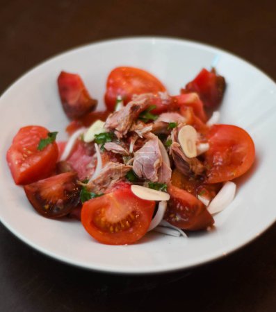 Tomato and tuna salad, with onion. Gourmet dish with quality tomatoes.