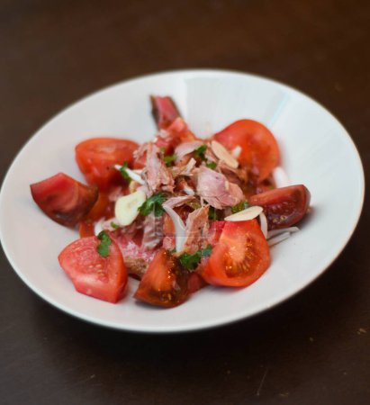 Tomato and tuna salad, with onion. Gourmet dish with quality tomatoes.