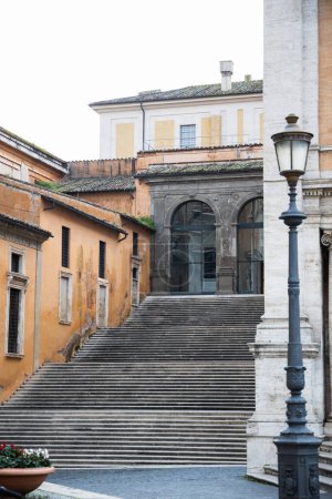 Téléchargez les photos : Escaliers à Rome avec des murs ocres sur le bâtiment, Étapes près de la place Campidoglio - en image libre de droit