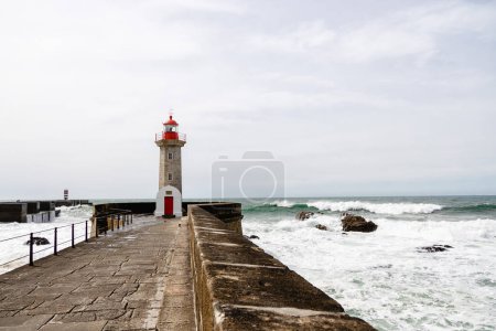 Felgueiras Lighthouse in Porto on the Atlantic coast with huge waves in a sunny day, splashing waves at Farol de Felgueiras