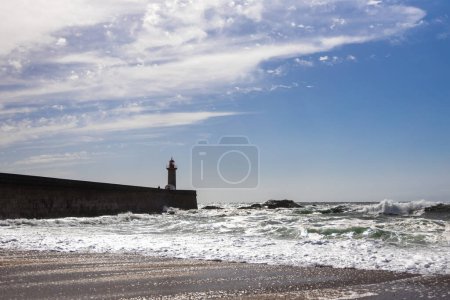 Felgueiras Lighthouse in Porto on the Atlantic coast with huge waves in a sunny day, splashing waves at `Farol de Felgueiras