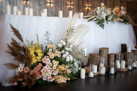 Photo for Romantic boho main table. Wedding decor for newlyweds at a banquet. Dried flowers floristry and candles, boho style. Cartering service for the bride and groom and guests. - Royalty Free Image