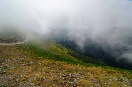 Photo for One tourist on a mountain trail walks into a cloud. - Royalty Free Image