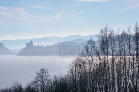 Photo for Czorsztyn. Malopolskie. Poland. 02/16/2024. Niedzica Castle shrouded in the rising morning fog. In the foreground, Lake Czorsztynskie. - Royalty Free Image