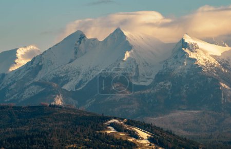 Photo for Mountains Landscape in winter. Tatra National Park- view from Czarna Gora. Mountain peaks illuminated by the rays of the setting sun shining through the clouds. Spisz. Malopolskie. Poland. - Royalty Free Image