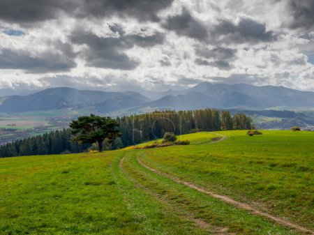 Landscape with dramatic sky. View of the Low TAtras. In the foreground, a meadow and country road. Zilina Region. Beszeniowa. Slovakia.