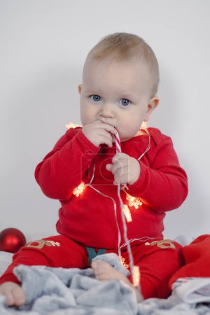 Téléchargez les photos : Portrait de Noël d'un beau petit enfant tenant une canne à bonbons - en image libre de droit