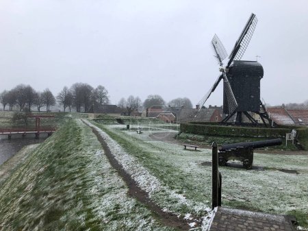 Téléchargez les photos : Moulin à vent sur l'île près du canal en hiver - en image libre de droit