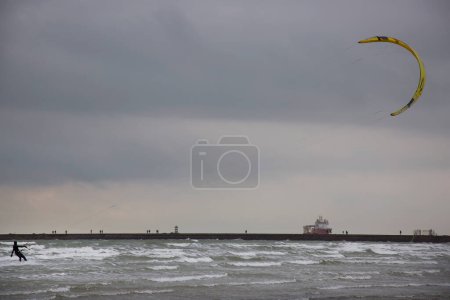 Téléchargez les photos : L'homme fait de la planche à voile dans la mer - en image libre de droit