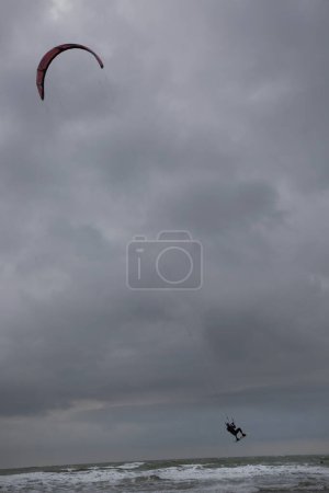 Téléchargez les photos : L'homme fait de la planche à voile dans la mer - en image libre de droit