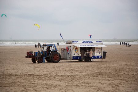 Photo for Tractor with fast food trailer on sea beach in cold day - Royalty Free Image