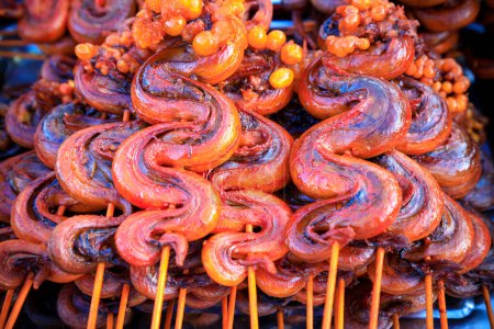 Cooked barbequed exotic street food snake in a market stall in Phnom Penh, Cambodia.