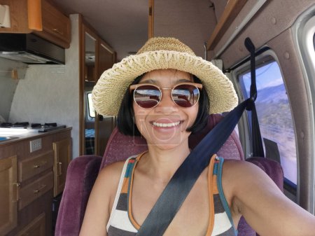 Téléchargez les photos : Jeune femme asiatique prenant selfie de siège passager à l'intérieur d'un véhicule camping-car. Liberté sur la route en Colombie-Britannique, Canada. - en image libre de droit